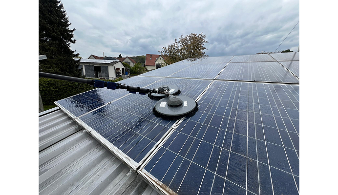 Hausdach mit Solarpaneelen, die gesäubert werden.